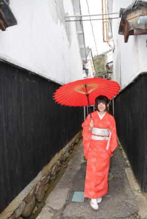 龍野の城下町の路地を赤い着物を着た女性が歩いている写真