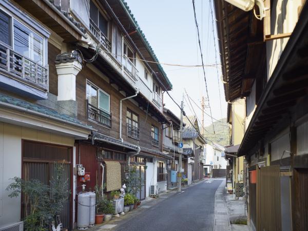 道路の両側に3階建ての窓の多い和風の家が並び、玄関の入口が道路側に向いた家が建つ九艘ノ町の写真