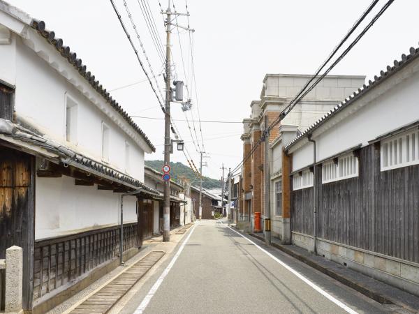 道路の両側に下側は木材が使われて上は白壁の和風造りの家が建ち並ぶ横町の写真