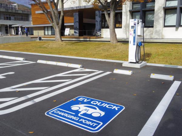 1台分の電気自動車用の駐車スペースと、そのスペースのそばに設置された電気自動車用充電器の写真