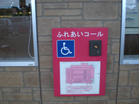壁面にインターフォンがあり、車いすマークが記された「ふれあいコール」が設置されている写真