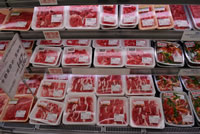 発泡トレーに入れられたお肉が商品棚に並べられている写真