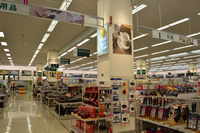 商品棚の間にある建物の柱に商品のLEDポスターパネルが設置されたり、置かれている商品の種類がかかれている看板の写真