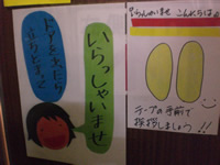 ドアを出たら立ち止まっていらっしゃいませを促すイラスト付き張り紙の写真
