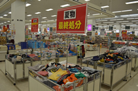 夏物最終処分と書かれたポップが立てられたワゴンに洋服がたくさん置かれている写真