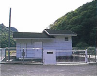 フェンスで囲まれた敷地内に、高さの違う黒い屋根のある建物が設置された能下加圧所の写真