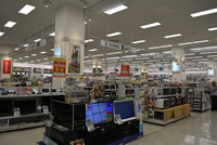 天井に「生活家電」と書かれた看板が設置され、売り場にテレビや電子レンジなどが陳列されている家電売り場の写真