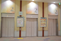 間にフロアガイドが設置された3つのエレベーター乗降口の写真