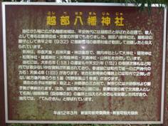 茶色の看板にタイトルが黄色の文字で「越部八幡神社」と書かれその下に白い文字で説明が書かれている写真
