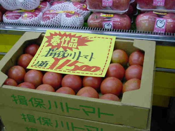 箱詰めされたトマトがPOPを貼られて、店頭に陳列されている写真