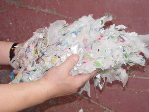取り除かれたプラスチック類を両手で持っている様子をアップで撮影した写真