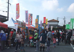 白や緑色などのテントやのぼり旗が設置された屋外の祭りの会場に、親子連れの大勢のお客さんがつめかけ賑わっているたつの市商工産業まつりの様子の写真
