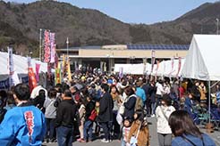 左右に白いテントが並んでいる会場に、大勢のお客さんがつめかけて賑わっている、しんぐう楽市楽座の様子の写真