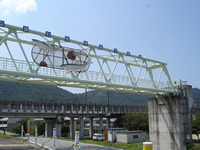 鉄道が通る高架橋と並行して設置され、表面に魚のイラストが描かれた揖保川流域下水道高架水管の写真
