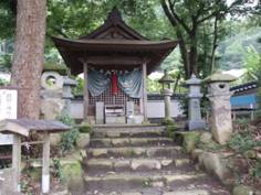 越部禅尼の墓と伝えられる祠を石を積み上げた階段側から撮影した写真