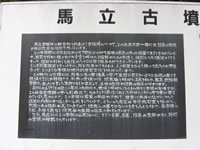 白い看板に黒文字で「馬立古墳」とタイトルが書かれ灰色の下地に白文字で説明が書かれている写真