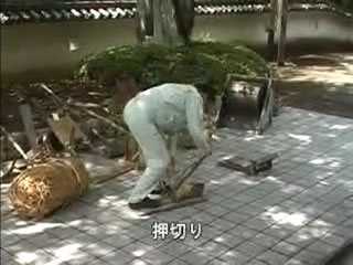 作業服を着た男性が、刃の付いた押切りでわらを短く切っている様子の写真（押切り（わたしたちのたつの市）のページへリンク）