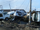 津波で流された複数台の車が積み重なっている写真
