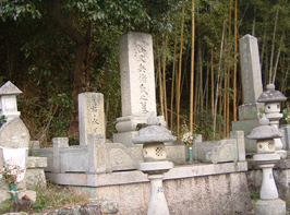 後ろが竹林になっている大きな石塔のお墓やお地蔵様の写真