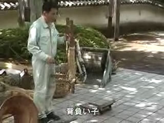 作業服を着た男性が、背負縄が付いた短い梯子の様な形をした背負子を持っている写真（背負い子（わたしたちのたつの市）のページへリンク）