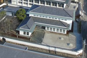 白壁で2階建ての霞城館の敷地全体を上空から撮影した写真