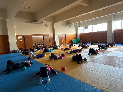 膝を立てた状態で仰向けに寝転び、ボールを使用して簡単ストレッチを行っている写真