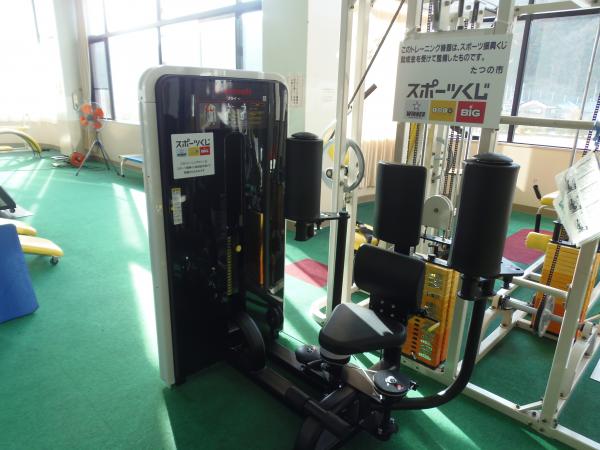 2つのトレーニング機器にスポーツ振興くじ助成金の看板が設置された新宮スポーツセンタートレーニング室内の写真