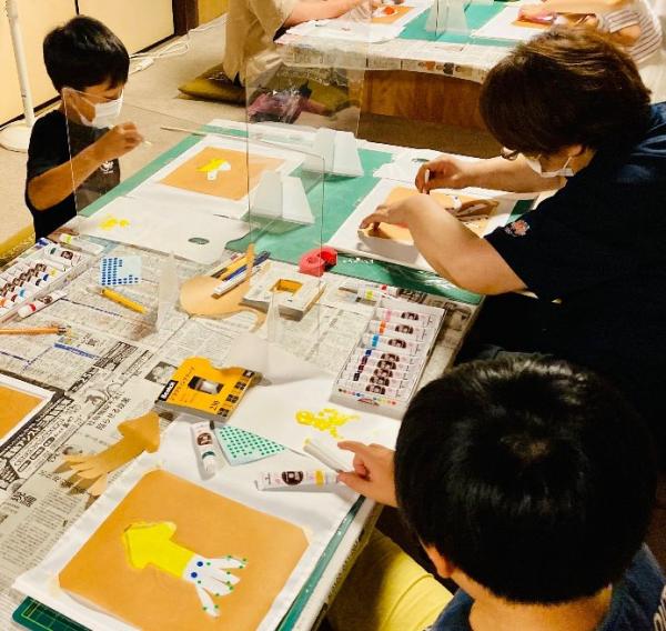 イカを描いた作品を作っている子供たちを撮影した写真