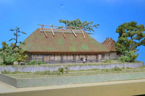 屋根が最頂部から4方向に傾斜している寄棟造りの家の模型の写真