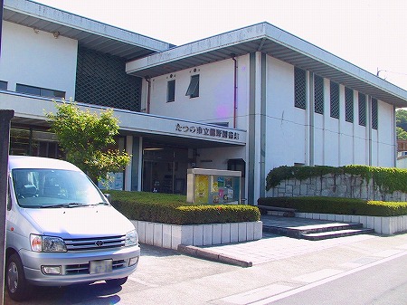 白い外壁の龍野図書館の建物とその入口そばの植え込みを斜め前から写した写真