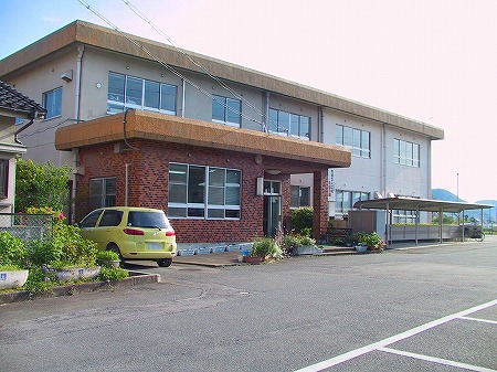 二階建ての揖保コミュニティセンターの建物と、その建物の前の駐車場を写した写真
