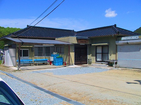 一階建てで、瓦屋根と薄い黄色の外壁の角亀公民館の写真