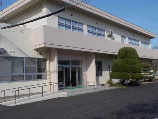 白っぽい外壁で2階のベランダがつながっている神岡コミュニティセンターの建物を斜め前から写した写真