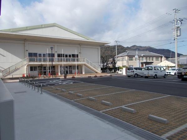 小宅小学校の体育館と、その前にある整備された駐車場の写真