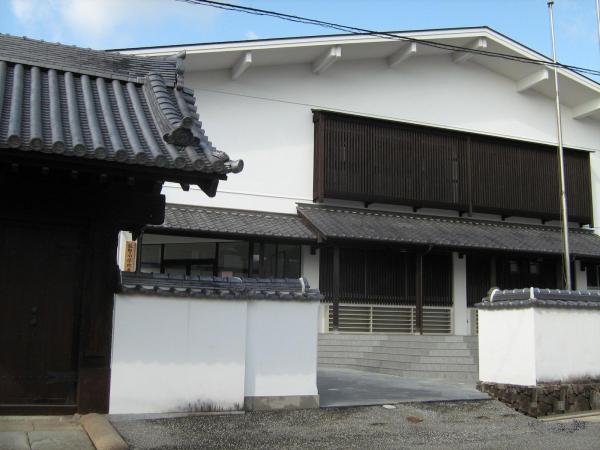 白い外壁で大きな窓に木製の格子がついている龍野小学校の屋内運動場の大きな建物の写真