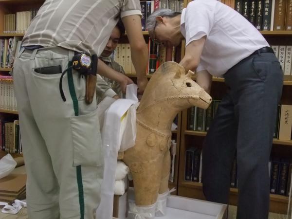 専門家と配達委員が埴輪を慎重に包装していく様子を撮影した写真