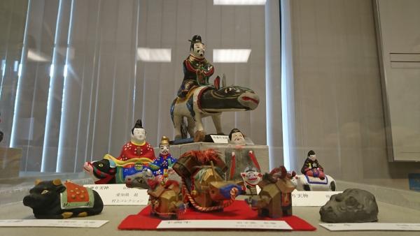 ロビーに展示されている、牛の背中に乗っている天神さまや牛の人形の作品数点の写真