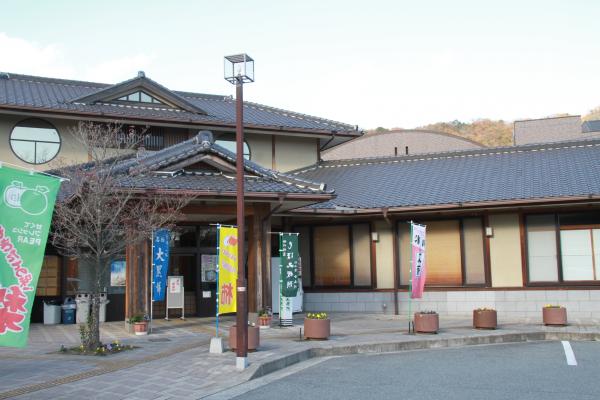 建物前に複数ののぼり旗が立ち、入口部分が三角屋根になっている道の駅しんぐうの外観写真