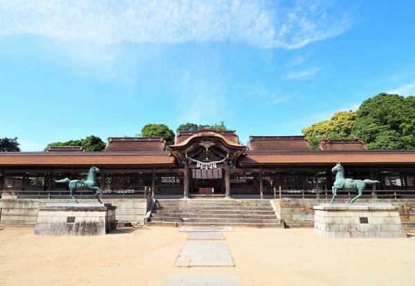 左右に駒馬が向かい合って設置された奥に拝殿が建っている賀茂神社の写真